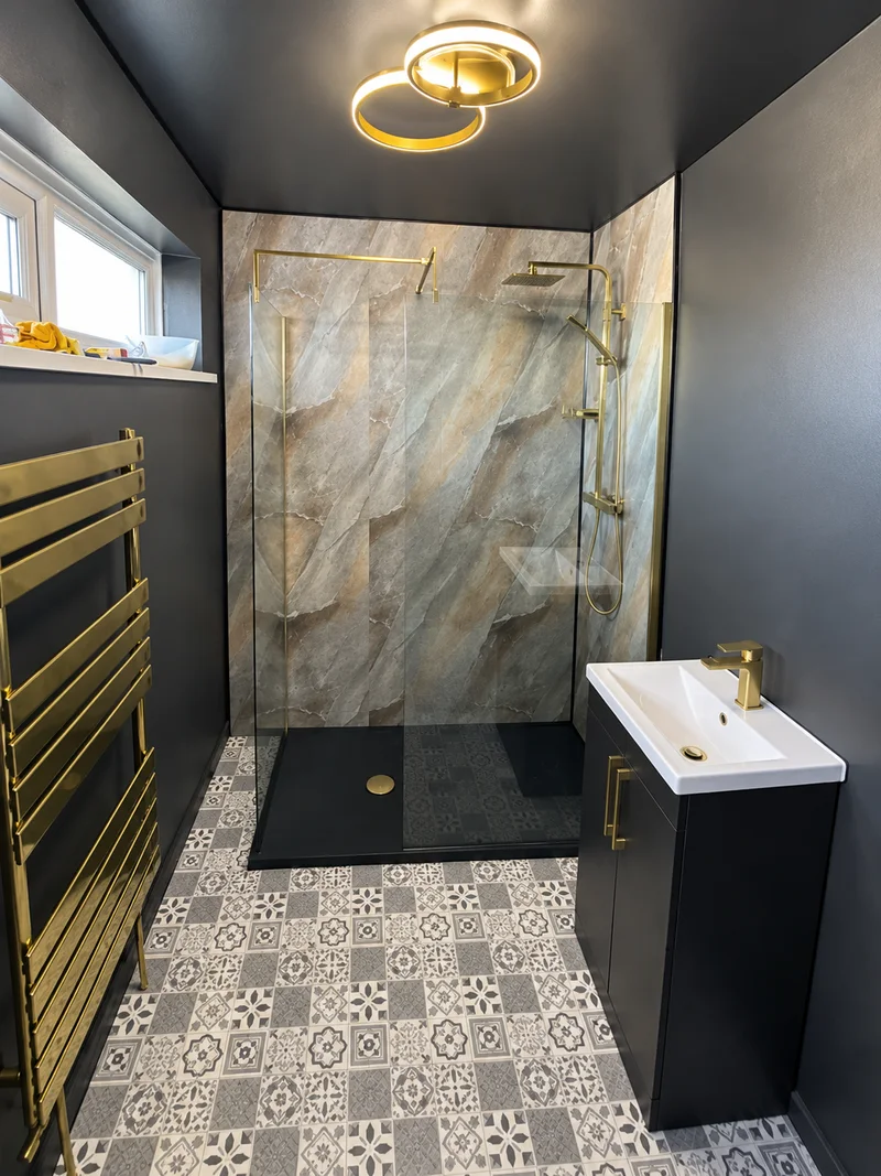 After renovation: walk-in shower, patterned floor and gold fittings; photo enhanced