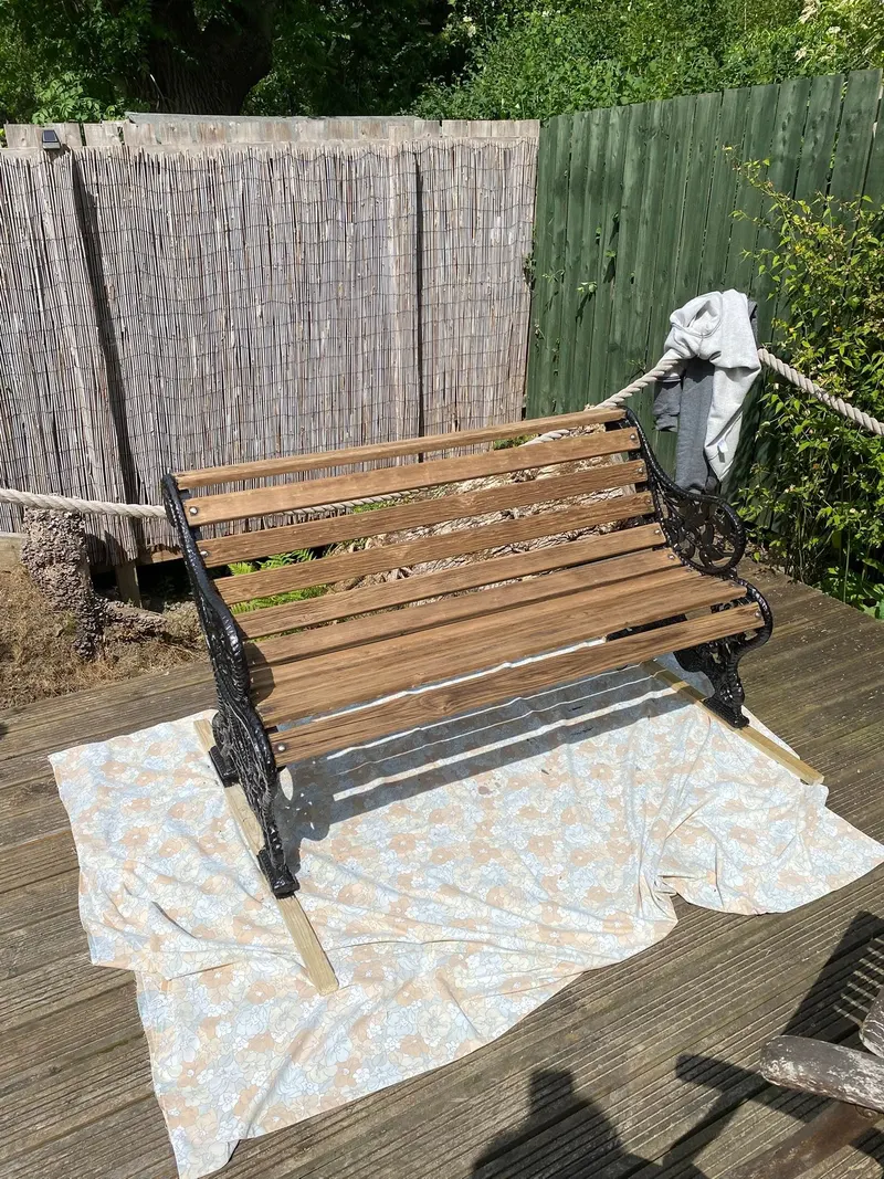 After: restored wooden slats and black metal bench frame
