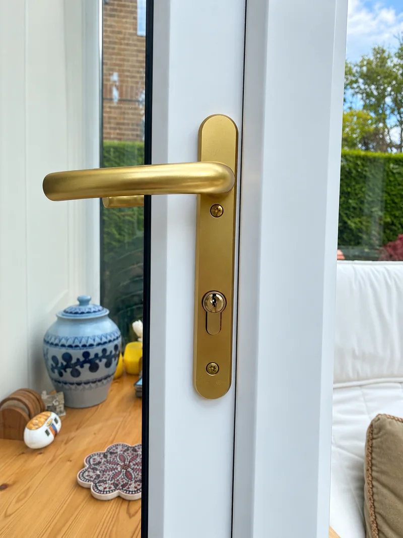 Brass door handle on a white glazed door; photo enhanced